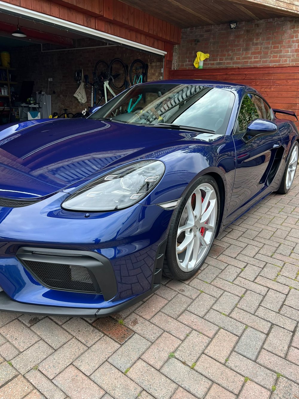 Blue Porsche 718 Cayman GT4 showing sharp reflections after a machine polish